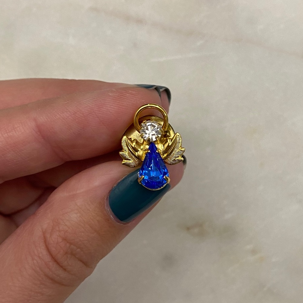 Gold-toned angel pin. Blue and white rhinestones